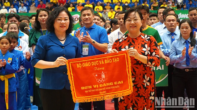 Thứ trưởng Giáo dục và Đào tạo Ngô Thị Minh trao cờ lưu niệm cho Giám đốc Sở Giáo dục và Đào tạo Nguyễn Thúy Hà, đại diện địa phương đăng cai