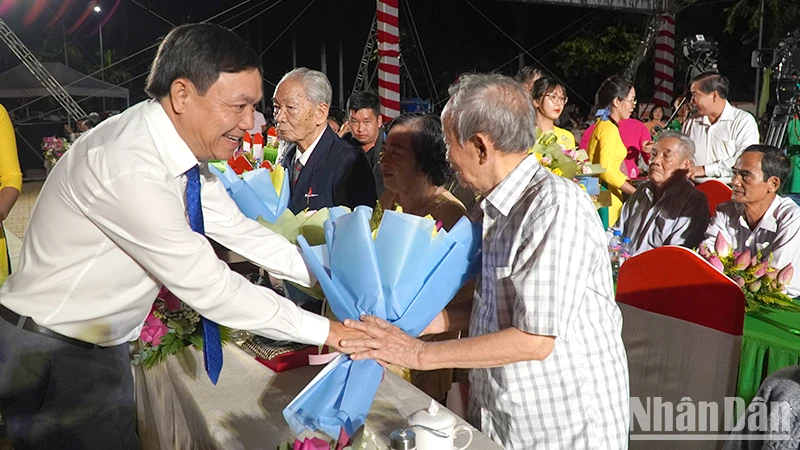 Phó Bí thư Thường trực Tỉnh ủy Đồng Tháp Phan Văn Thắng tặng hoa nhân chứng lịch sử. (Ảnh: HỮU NGHĨA)