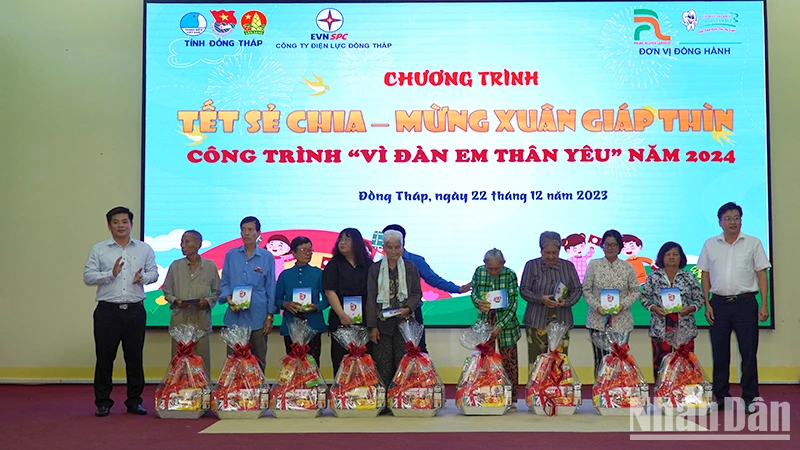 Chủ tịch Ủy ban nhân dân huyện Tháp Mười Đoàn Thanh Bình và Phó Giám đốc Công ty Điện lực Đồng Tháp Nguyễn Chí Thanh trao tặng quà. (Ảnh: HỮU NGHĨA)