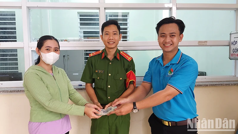 Công an phường 6 và anh Nguyễn Minh Toàn bàn giao lại chiếc ví cho chị Lê Thị Huỳnh Oanh.