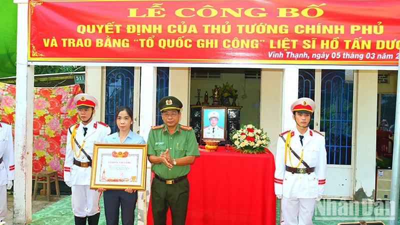 Đại tá Nguyễn Văn Hiểu, Giám đốc Công an tỉnh Đồng Tháp trao Bằng “Tổ quốc ghi công” cho vợ Liệt sĩ Hồ Tấn Dương.