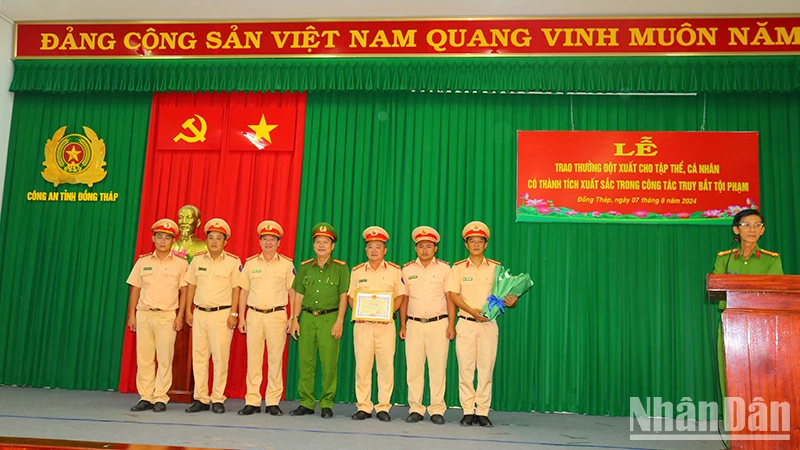 Lãnh đạo Công an huyện Cái Bè, tỉnh Tiền Giang và lãnh đạo Phòng Cảnh sát giao thông, Công an tỉnh Đồng Tháp trao giấy khen cho tập thể có thành tích trong bắt các đối tượng cướp và cố ý gây thương tích. (Ảnh: PHƯỚC THANH)