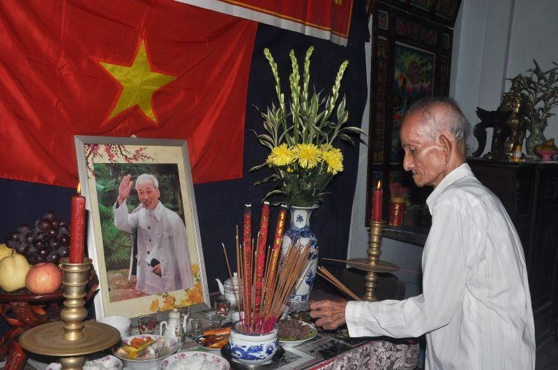 Đảng viên là nông dân Huỳnh Văn Tấn thắp hương bên bàn thờ Bác Hồ.