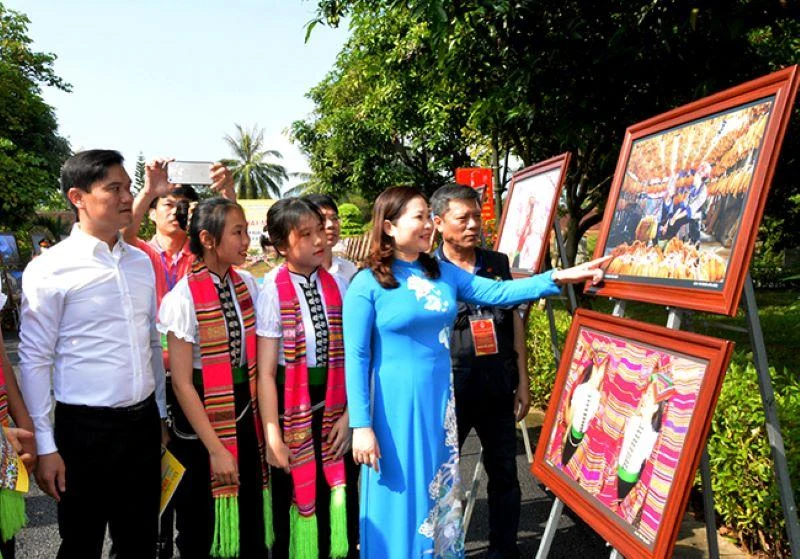 Các đại biểu và học sinh tham quan triển lãm ảnh.