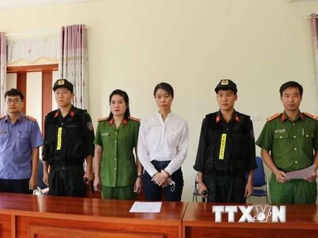 Bị can Nguyễn Thị Hồng Nhung nhận quyết định khởi tố và lệnh bắt tạm giam. (Ảnh: Đinh Thùy/TTXVN)