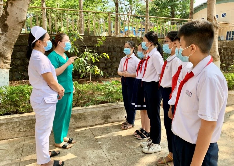 Nhân viên y tế phường Hoa Lư (TP. Pleiku, Gia Lai) tuyên truyền về phòng, chống dịch Covid-19 cho các em học sinh. (Ảnh: Như Nguyện) 