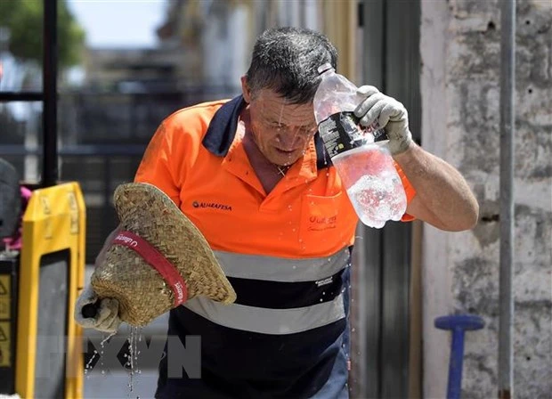 Công nhân làm mát dưới trời nắng nóng ở Sevilla, Tây Ban Nha. (Ảnh: AFP/TTXVN)