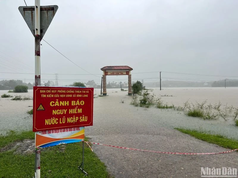 Chính quyền địa phương ở huyện Bình Sơn (Quảng Ngãi) rào chắn, cắm biển cảnh báo nguy hiểm trên các tuyến đường bị ngập lụt. 