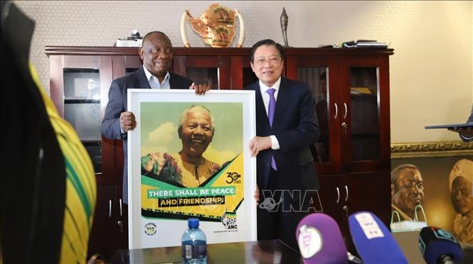 Chủ tịch đảng ANC, Tổng thống Nam Phi Cyril Ramaphosa (trái) tặng quà lưu niệm đồng chí Phan Đình Trạc tại trụ sở đảng. (Ảnh: TTXVN)