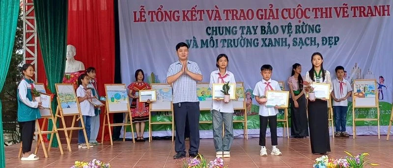 Ông Nguyễn Đức Quang, Trưởng Phòng Giáo dục và Đào tạo huyện Mường Ảng, trao giải cho học sinh Trường Trung học cơ sở Xuân Lao có tranh vẽ xuất sắc về chủ đề môi trường.