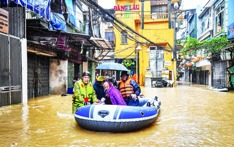 Lực lượng chức năng ứng cứu, giúp người dân khu vực phường Phúc Tân (quận Hoàn Kiếm, Hà Nội) di chuyển đến nơi an toàn khi nước lũ lên nhanh, nhiều khu vực bị ngập sâu. Ảnh: Thành Đạt