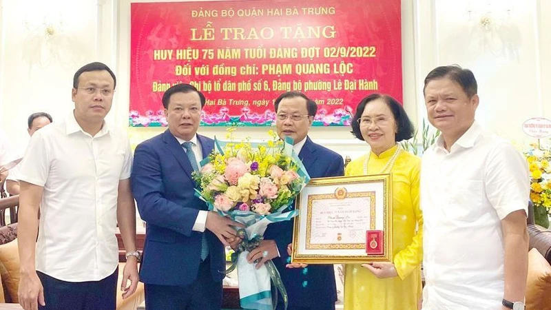 Bí thư Thành ủy Hà Nội Đinh Tiến Dũng trao Huy hiệu 75 năm tuổi Đảng cho đại diện gia đình đồng chí Phạm Quang Lộc.