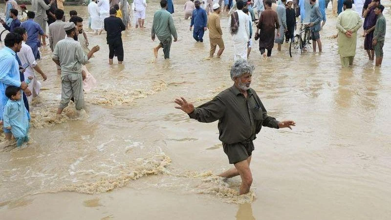Người dân di chuyển trên con đường bị ngập tại Charsadda, Pakistan. (Ảnh: Reuters)