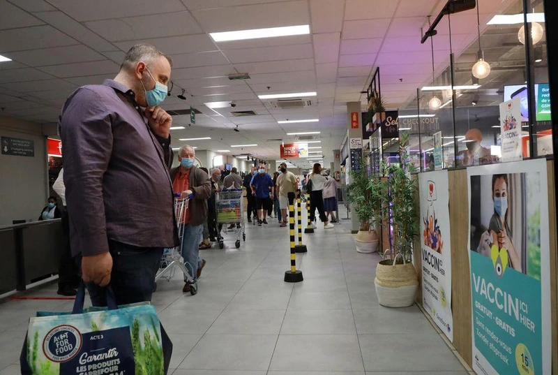 Một người mua sắm đọc thông tin trên áp-phích của một trung tâm tiêm chủng ngừa Covid-19 bên trong một siêu thị tại thủ đô Brussels, Bỉ, ngày 30/8/2021. (Ảnh: Reuters) 