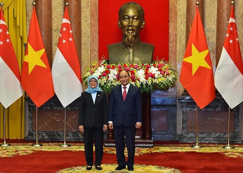 Chủ tịch nước Nguyễn Xuân Phúc và Tổng thống Singapore Halimah Yacob chụp ảnh chung tại lễ đón. (Ảnh: Thủy Nguyên)