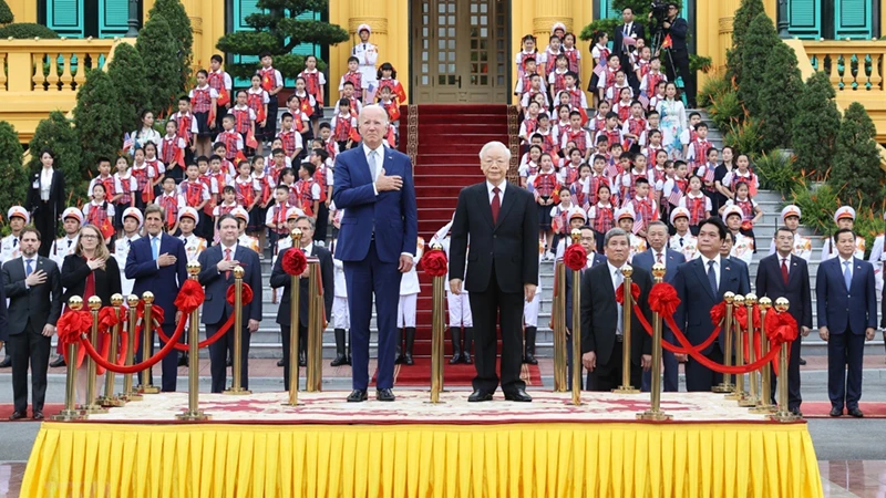 Tổng Bí thư Nguyễn Phú Trọng và Tổng thống Hoa Kỳ Joe Biden trên bục danh dự, thực hiện nghi thức chào cờ. (Ảnh: TTXVN) 