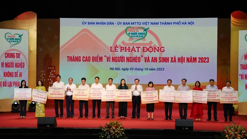 Bí thư Thành ủy Hà Nội Đinh Tiến Dũng và Phó Chủ tịch Ủy ban Mặt trận Tổ quốc Việt Nam Hoàng Công Thủy trao kinh phí hỗ trợ hộ nghèo cho các huyện, thị xã của Hà Nội.