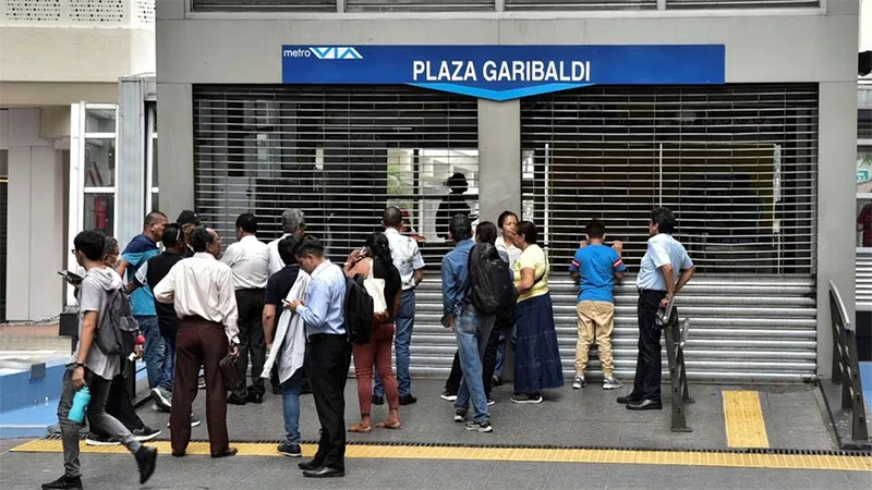 Người dân đứng bên ngoài nhà ga Plaza Garibaldi vừa bị đóng cửa sau khi bạo lực bùng phát, ngày 9/1/2024. Ảnh: REUTERS