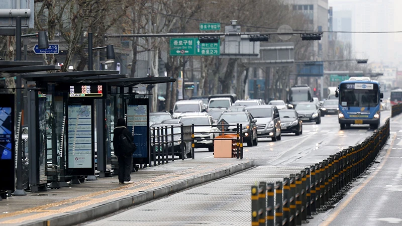 Hành khách đang đợi xe buýt tại điểm chờ xe ở trung tâm Seoul, Hàn Quốc, ngày 28/3/2024. (Ảnh: Yonhap)