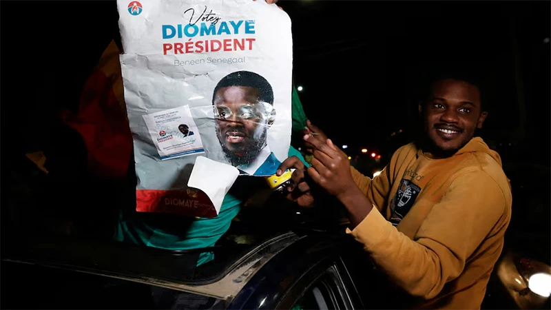 Người ủng hộ ông Bassirou Diomaye Faye mang theo poster chân dung ông. (Ảnh: Reuters) 