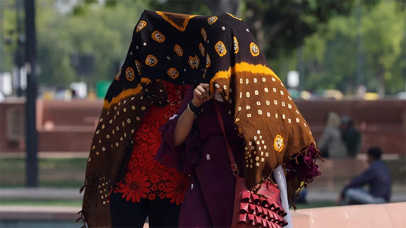 Người dân di chuyển dưới thời tiết nắng nóng tại New Delhi, Ấn Độ, ngày 15/5/2023. (Ảnh: Reuters)