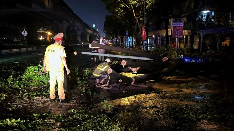 Cảnh sát giao thông tham gia khắc phục hậu quả sau trận mưa lớn đêm 20, rạng sáng 21/4 tại Hà Nội.