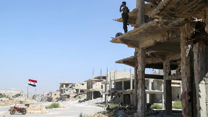 Một binh sĩ của Syria đứng trên tòa nhà bị hư hại ở Deraa al Balaad, Syria, ngày 9/9/2021. (Ảnh: Reuters)