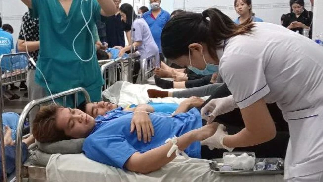 Các y, bác sĩ Trung tâm Y tế huyện Trảng Bom tập trung điều trị các công nhân nhập viện nghi bị ngộ độc sau khi ăn bánh đa cua.