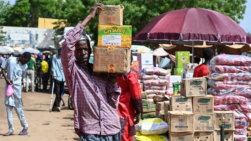 Người dân chuyển lương thực tại khu chợ ở Niamey (Niger). (Ảnh: AFP/TTXVN)