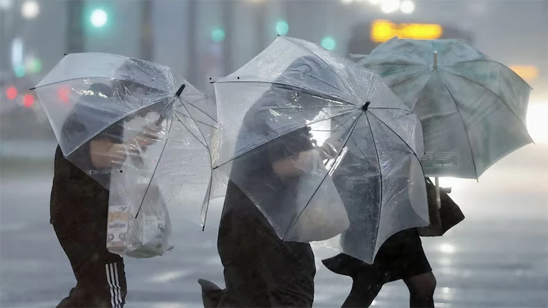 Người dân di chuyển trong thời tiết có mưa lớn và gió mạnh tại Kagoshima, ngày 28/8/2024. (Ảnh: Reuters)