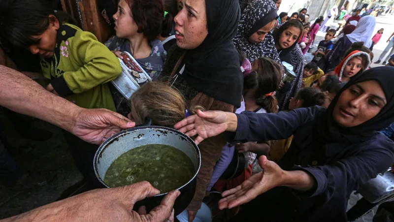 Người tị nạn Palestine nhận thức ăn cứu trợ tại thành phố Deir al-Balah, miền trung Gaza ngày 25/10/2024. (Ảnh: THX/TTXVN)