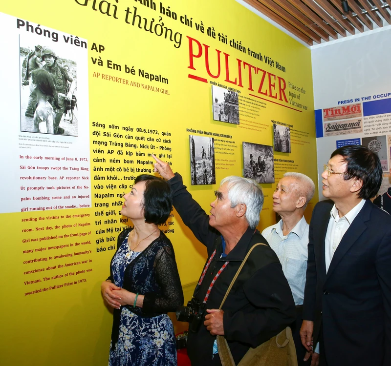 Kim Phúc (bên trái) và Nick Út (thứ hai, trái sang) xem lại những bức ảnh lịch sử. Ảnh: SƠN HẢI