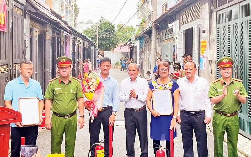 Lãnh đạo Phòng Cảnh sát Phòng cháy, chữa cháy và Cứu nạn, cứu hộ Công an Thành phố Hồ Chí Minh trao bình chữa cháy, dụng cụ hỗ trợ phòng cháy cho người dân hẻm 51, đường Tân Chánh Hiệp 08, phường Tân Chánh Hiệp, quận 12 khi ra mắt mô hình Tổ liên gia an toàn phòng cháy, chữa cháy.