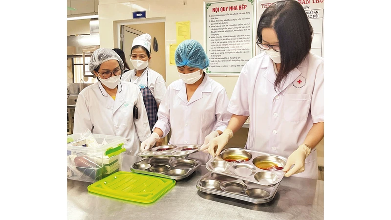 Ðoàn kiểm tra vệ sinh an toàn thực phẩm xét nghiệm nhanh khay đựng thức ăn tại Trường tiểu học Phúc Tân (quận Hoàn Kiếm).