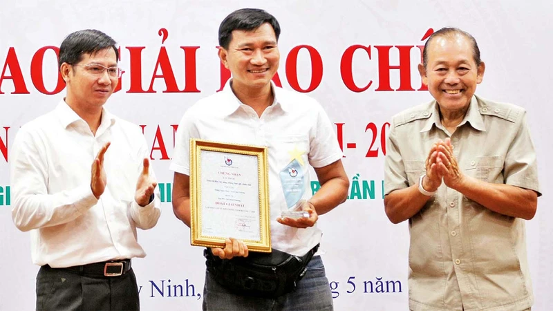 Nguyên Phó Thủ tướng Trương Hòa Bình (bên phải) và Bí thư Tỉnh ủy Tây Ninh Nguyễn Thành Tâm (bên trái) trao Giải nhất cho tác giả. 
