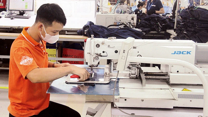 Người lao động ở Thanh Hóa bảo dưỡng thiết bị may công nghiệp.