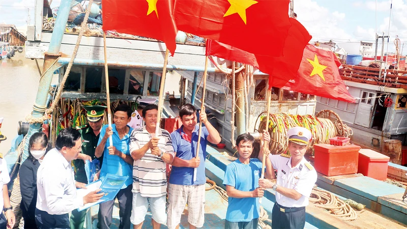 Hải quân Vùng 2 trao cờ Tổ quốc tặng ngư dân thị trấn Ðịnh An, huyện Trà Cú.