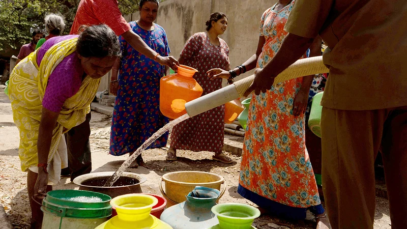 Người dân thành phố Bengaluru, miền nam Ấn Ðộ xếp hàng lấy nước. (Ảnh REUTERS)