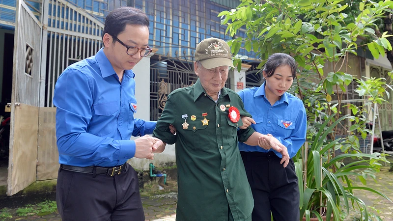 Các cán bộ đoàn đưa cựu chiến binh Nguyễn Phương Ðàn (99 tuổi, trú phường Noong Bua, thành phố Ðiện Biên Phủ, tỉnh Ðiện Biên) đi thăm lại chiến trường năm xưa.