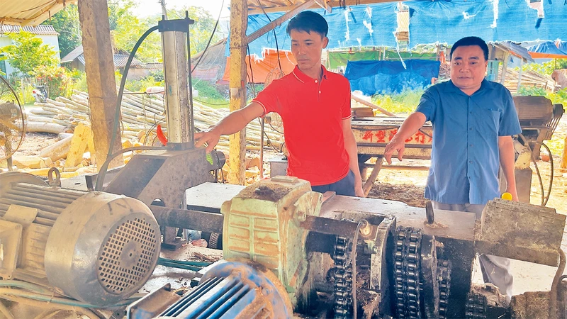 Anh Nguyễn Văn Công (người bên trái) trao đổi cách sản xuất hiệu quả với hội viên cựu chiến binh trong xã.