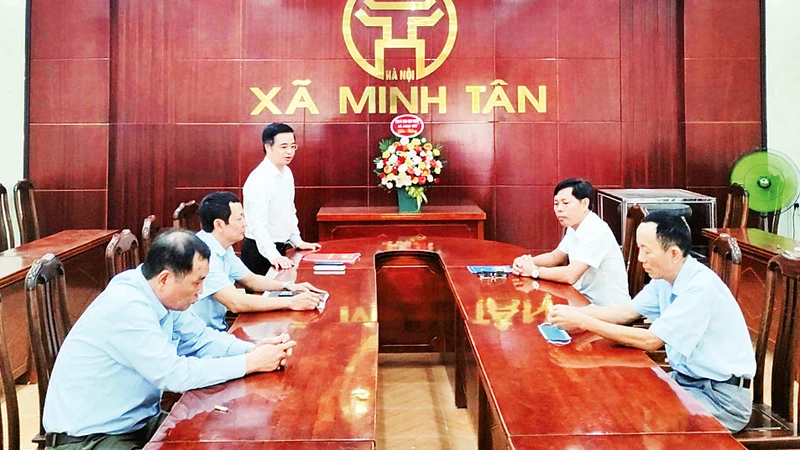 Bí thư Ðảng ủy xã Minh Tân (huyện Phú Xuyên) Trương Ðại Dương (người đứng) chủ trì họp giao ban để nắm bắt thông tin từ cơ sở. (Ảnh HỮU HẢI)