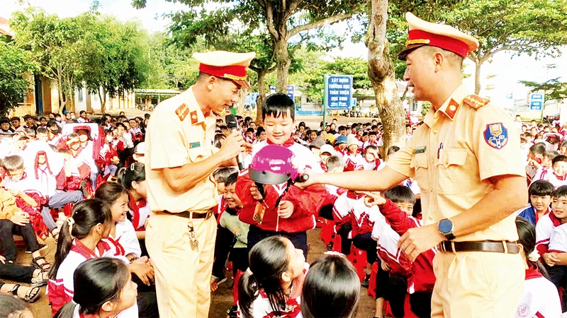 Công an tỉnh Đắk Lắk tuyên truyền, hướng dẫn học sinh đội mũ bảo hiểm đúng quy cách khi tham gia giao thông.