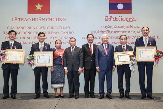Chủ tịch Ủy ban Trung ương Mặt trận Lào xây dựng đất nước Sinlavong Khoutphaythoune và Chủ tịch Ủy ban Trung ương MTTQ Việt Nam Đỗ Văn Chiến chụp ảnh lưu niệm với các cá nhân được nhận Huân chương Ít-xa-la hạng II, III 
