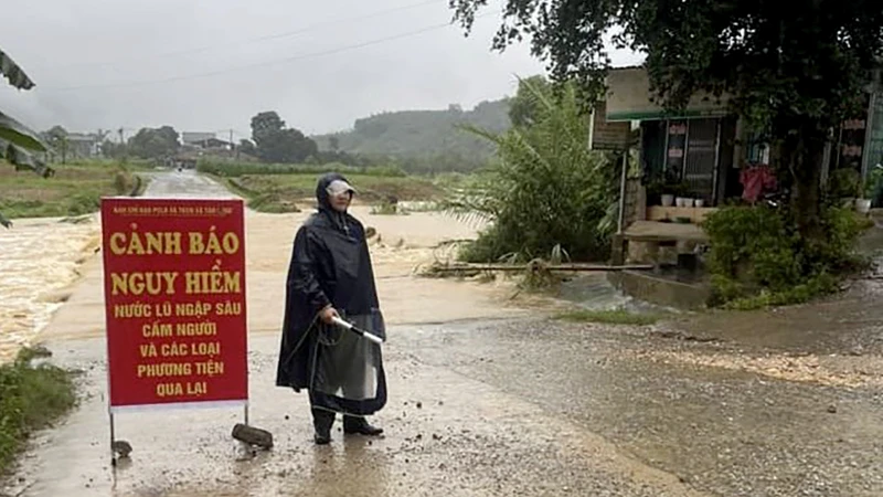 Lực lượng chức năng chốt chặn tại điểm ngập úng xã Tân Long, huyện Yên Sơn, không cho phương tiện đi qua khi nước lũ lên cao. 