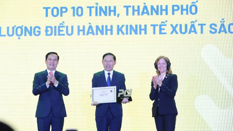 Chủ tịch Ủy ban nhân dân tỉnh Bắc Giang Lê Ánh Dương (giữa) nhận kỷ niệm chương dành cho 10 tỉnh, thành phố xuất sắc nhất cả nước về thực hiện PCI năm 2022.