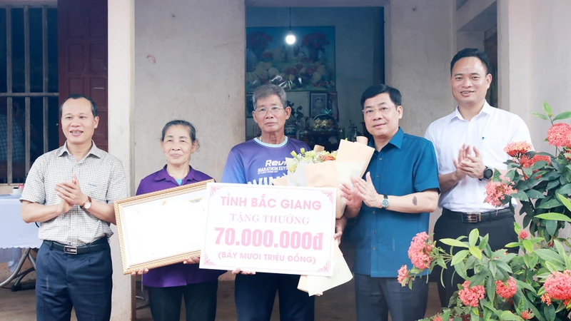 Bí thư Tỉnh ủy Bắc Giang Dương Văn Thái (thứ 2, phải sang) tặng quà cho đại diện gia đình vận động viên Nguyễn Thị Oanh.