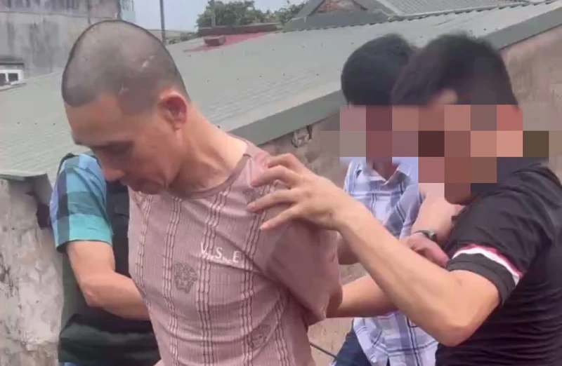 Lực lượng công an bắt giữ đối tượng Ngô Văn Đô trên mái nhà.