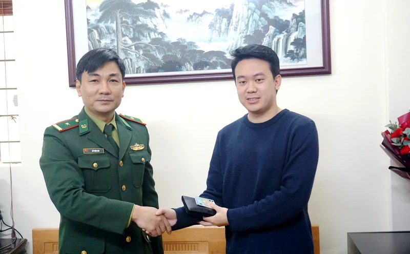 Thiếu tá Phùng Văn Yên trao trả tài sản cho anh Lê Việt Hùng, ở phường Kim Tân, thành phố Lào Cai. (Ảnh: QUỐC HỒNG)