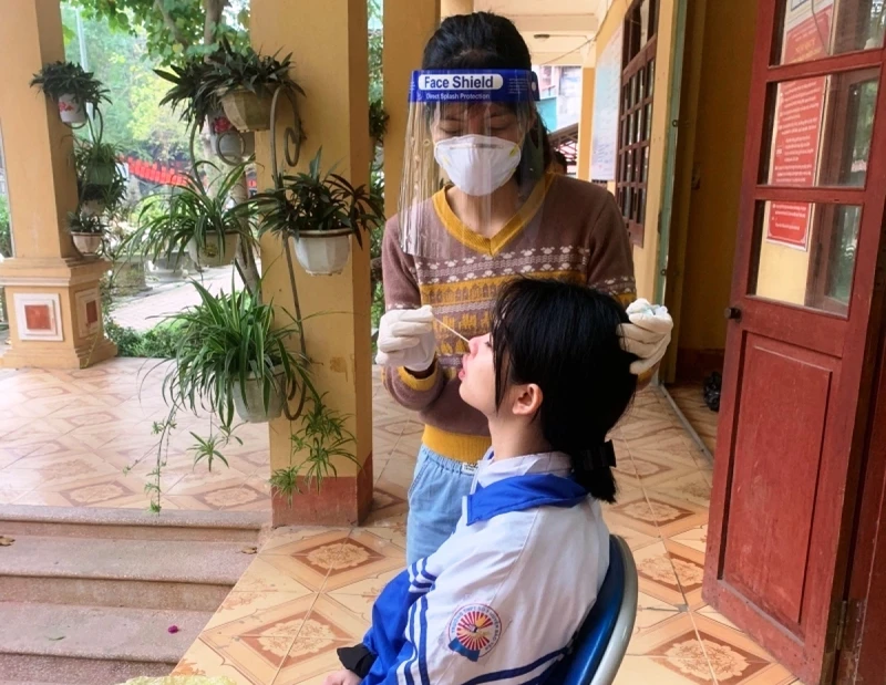 Lấy mẫu xét nghiệm cúm A trên học sinh ở thị trấn Phố Ràng, huyện Bảo Yên, tỉnh Lào Cai. (Ảnh TL)