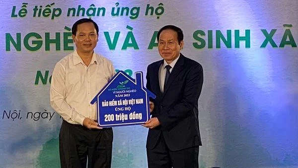 Phó Tổng Giám đốc Bảo hiểm xã hội Việt Nam Chu Mạnh Sinh (trái) trao 200 triệu đồng ủng hộ Quỹ Vì người nghèo năm 2022. (Ảnh: VSS)